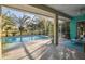 Enclosed patio with a pool, featuring a lush palm tree view and room for seating at 5261 Waterwood Dr, Bartow, FL 33830