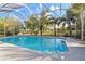 Relaxing screened-in pool area with a spacious deck and lush greenery; the perfect outdoor escape at 5261 Waterwood Dr, Bartow, FL 33830