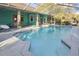 Backyard pool with screen enclosure and a brightly painted house at 5261 Waterwood Dr, Bartow, FL 33830