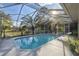 Backyard pool with screen enclosure is surrounded by plants and patio furniture at 5261 Waterwood Dr, Bartow, FL 33830