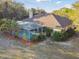 Back exterior featuring a screened-in pool area surrounded by lush landscaping and trees at 5261 Waterwood Dr, Bartow, FL 33830