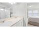 Bright bathroom with double sinks and a view of the primary bedroom at 1324 Painted Bunting Ave, Oakland, FL 34787