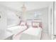 Charming bedroom featuring two twin beds with pink accents, complemented by a stylish chandelier at 1324 Painted Bunting Ave, Winter Garden, FL 34787