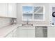 Close up of the kitchen featuring granite counters, white cabinets, backsplash and stainless steel dishwasher at 1324 Painted Bunting Ave, Winter Garden, FL 34787