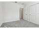 A clean bedroom featuring light gray carpet and a door leading to another room at 2530 Linda Knoll Ln, Bartow, FL 33830