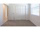 This bedroom has neutral carpet, a double closet, and a window letting in natural light at 2530 Linda Knoll Ln, Bartow, FL 33830