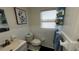 Bright bathroom with white tiling, decorative shelves, and a charming floral art piece at 3254 E Canal Ln, Fort Meade, FL 33841