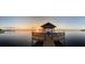 Stunning waterfront view with covered dock, boat lift, benches, and spectacular sunrise, ideal for relaxation at 3254 E Canal Ln, Fort Meade, FL 33841