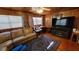 Relaxing living room showcasing wood paneling, a plush sofa, and a large flat-screen TV at 3254 E Canal Ln, Fort Meade, FL 33841