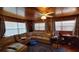 Cozy living room featuring wood paneling, large sectional sofa, and ceiling fan at 3254 E Canal Ln, Fort Meade, FL 33841