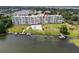 Waterfront condominium with a beautiful pool, boat docks, and lush landscaping with mature trees and green grass at 700 Mirror Nw Ter # 505, Winter Haven, FL 33881