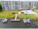 Aerial shot of a lakefront condo featuring docks, boats, a pool, and green spaces at 700 Mirror Nw Ter # 505, Winter Haven, FL 33881