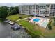 Aerial view showcases a community pool, shuffleboard court, and docks on the lake at 700 Mirror Nw Ter # 505, Winter Haven, FL 33881