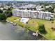 Aerial view features a waterfront building with a pool, docks, and lush greenery at 700 Mirror Nw Ter # 505, Winter Haven, FL 33881