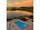 The outdoor pool and well-maintained pool deck provide a relaxing space with beautiful sunset views of the lake at 700 Mirror Nw Ter # 505, Winter Haven, FL 33881