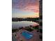 Aerial view of a lakefront building with pool and dock, captured at sunset at 700 Mirror Nw Ter # 505, Winter Haven, FL 33881