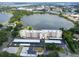 An aerial shot displays a building next to a lake surrounded by lush landscape at 700 Mirror Nw Ter # 505, Winter Haven, FL 33881