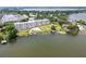 An aerial shot of a condominium complex and the lake, showing greenery and nearby properties at 700 Mirror Nw Ter # 505, Winter Haven, FL 33881