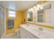 Bright bathroom featuring a dual vanity sink, tiled shower, and large mirror at 700 Mirror Nw Ter # 505, Winter Haven, FL 33881