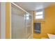 Bathroom showcasing a modern shower with a sleek sliding glass door and textured yellow walls at 700 Mirror Nw Ter # 505, Winter Haven, FL 33881