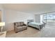 Bright bedroom features neutral carpet, a love seat, and sliding glass doors to the screened porch at 700 Mirror Nw Ter # 505, Winter Haven, FL 33881