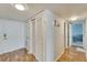 Hallway with wood-look flooring and white walls featuring a closet and an open doorway to the main living area at 700 Mirror Nw Ter # 505, Winter Haven, FL 33881