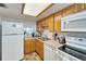 Bright kitchen with light wood cabinets, laminate counters, and white appliances at 700 Mirror Nw Ter # 505, Winter Haven, FL 33881