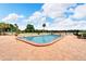 Pool at the community with blue skies, pool furniture, and a lake view at 700 Mirror Nw Ter # 505, Winter Haven, FL 33881