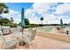 Outdoor patio features a shuffleboard court, table with umbrella, and grill for outdoor entertaining at 700 Mirror Nw Ter # 505, Winter Haven, FL 33881