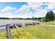 Picturesque waterfront view showcasing lush landscaping, a private dock with boats, and tranquil waters at 700 Mirror Nw Ter # 505, Winter Haven, FL 33881