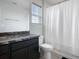 Bathroom features a single sink vanity and a shower with a white curtain at 1741 Hill Top Dr, Dundee, FL 33838