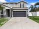 Home exterior showcasing a gray two-car garage and solar panels at 1741 Hill Top Dr, Dundee, FL 33838