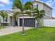 Charming two-story home featuring a gray garage door, stone accents, and lush landscaping at 1741 Hill Top Dr, Dundee, FL 33838