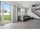 Modern living room featuring gray tile flooring, a gray sectional sofa, and a sliding glass door to the backyard at 1741 Hill Top Dr, Dundee, FL 33838