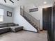 Bright living room showcasing staircase with iron railings, gray flooring, and comfortable gray sectional sofa at 1741 Hill Top Dr, Dundee, FL 33838