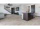 Open-concept living area featuring a modern kitchen island, wood-look tile flooring, and staircase at 1741 Hill Top Dr, Dundee, FL 33838