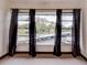 Bedroom view showing curtains overlooking the parking area with mature trees beyond the parking area at 333 Lake Howard Dr Nw # 314D, Winter Haven, FL 33880