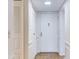 Hallway featuring large closets, entry door, and neutral tile flooring at 333 Lake Howard Dr Nw # 314D, Winter Haven, FL 33880