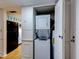 A compact laundry area featuring a stacked washer and dryer unit, adjacent to the kitchen appliances at 333 Lake Howard Dr Nw # 314D, Winter Haven, FL 33880