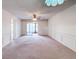Bright living room featuring neutral tones, ceiling fan, and sliding glass door to a balcony at 333 Lake Howard Dr Nw # 314D, Winter Haven, FL 33880