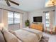 Well lit main bedroom featuring neutral decor, natural light, and hardwood dresser at 333 Lake Howard Dr Nw # 314D, Winter Haven, FL 33880