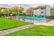 Community pool, featuring black fence surround, mature trees, and manicured landscaping at 333 Lake Howard Dr Nw # 314D, Winter Haven, FL 33880