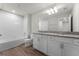 Well-lit bathroom with double vanity, granite countertops, tiled shower, and wood-look flooring at 3798 Plainview Dr, Orlando, FL 32824