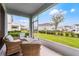 Cozy screened porch featuring comfortable wicker furniture overlooking the well-maintained community green space at 3798 Plainview Dr, Orlando, FL 32824