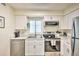 Well-lit kitchen featuring stainless steel appliances, white cabinets, and stylish countertop at 1404 N Atlantic Ave # 270, Daytona Beach, FL 32118