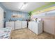 Bright laundry room with multiple washers and dryers, colorful wall decor, and a convenient folding table for residents at 1404 N Atlantic Ave # 270, Daytona Beach, FL 32118