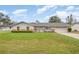 Charming single-story home featuring a well-manicured lawn and a light blue front door at 5105 Se 25Th St, Ocala, FL 34480