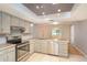 Well-lit kitchen featuring stainless steel appliances, tile countertops, and updated cabinetry at 5105 Se 25Th St, Ocala, FL 34480