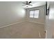 A clean bedroom features neutral walls, carpet, ceiling fan, and window with blinds at 6488 Sw 78Th Ct, Ocala, FL 34474