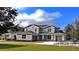 Beautiful two-story home featuring gray siding, a well-manicured lawn, and a three-car garage at 6488 Sw 78Th Ct, Ocala, FL 34474